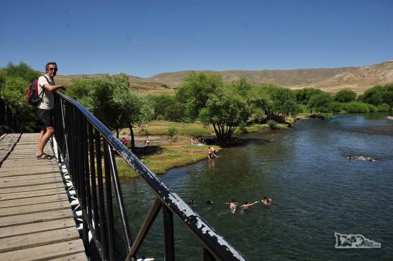 Pessoas nadam no delicioso rio de águas limpas e transparentes que corta a cidade de Junín de Los Andes, na Argentina